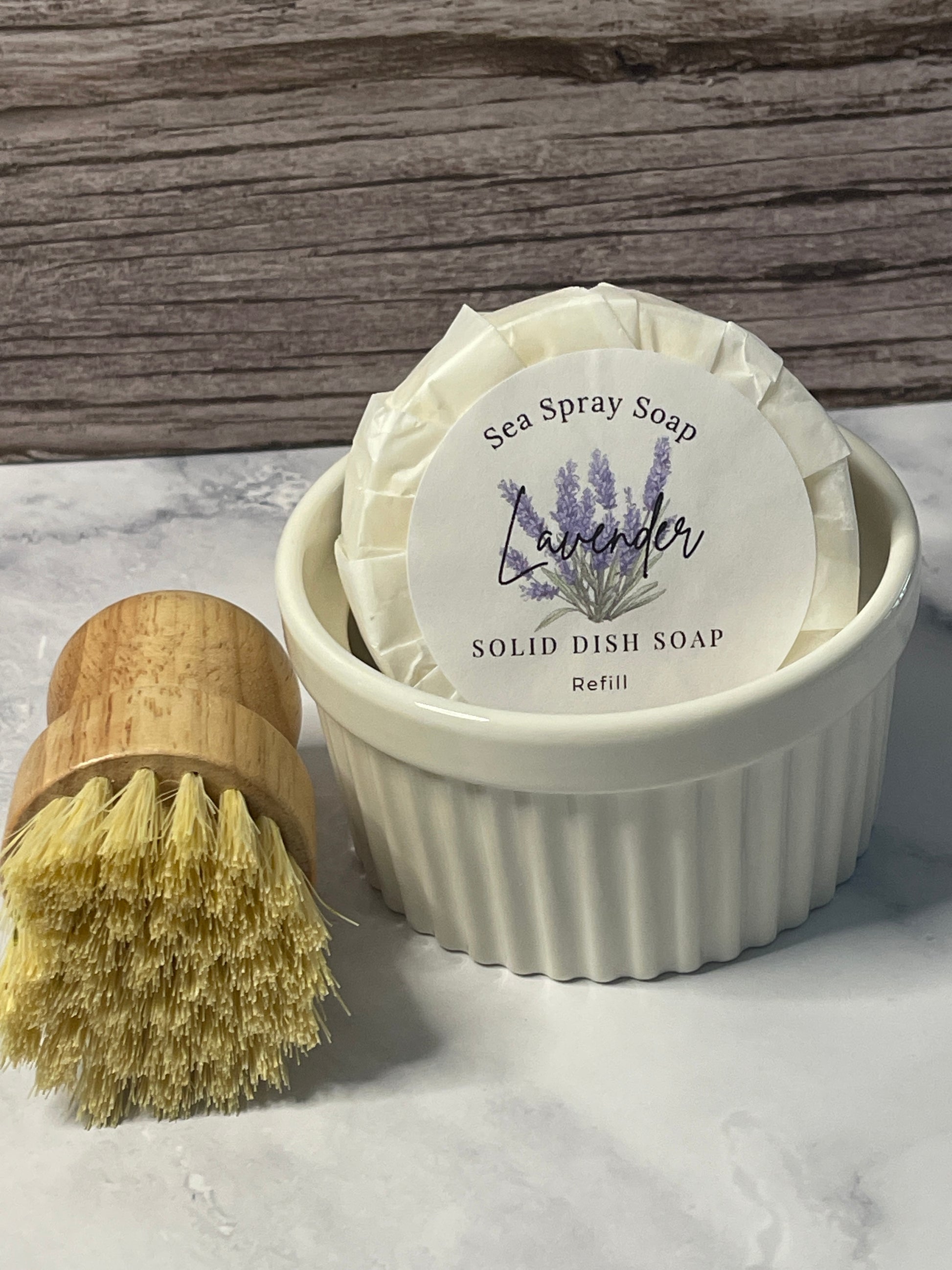 Solid dish soap refill with a brush on a wooden and marble surface