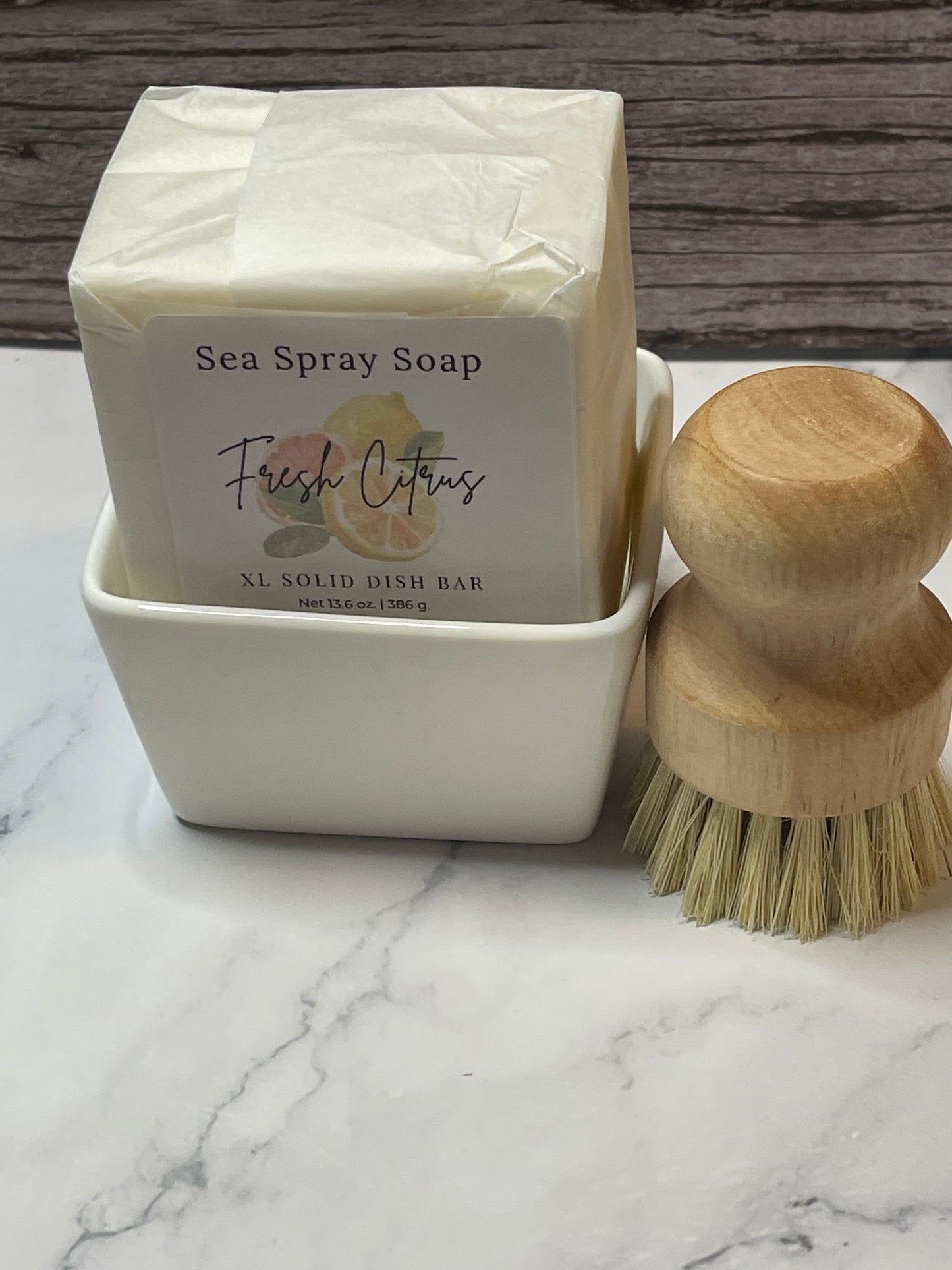 Bar of sea spray solid dish soap with a wooden brush on a marble surface