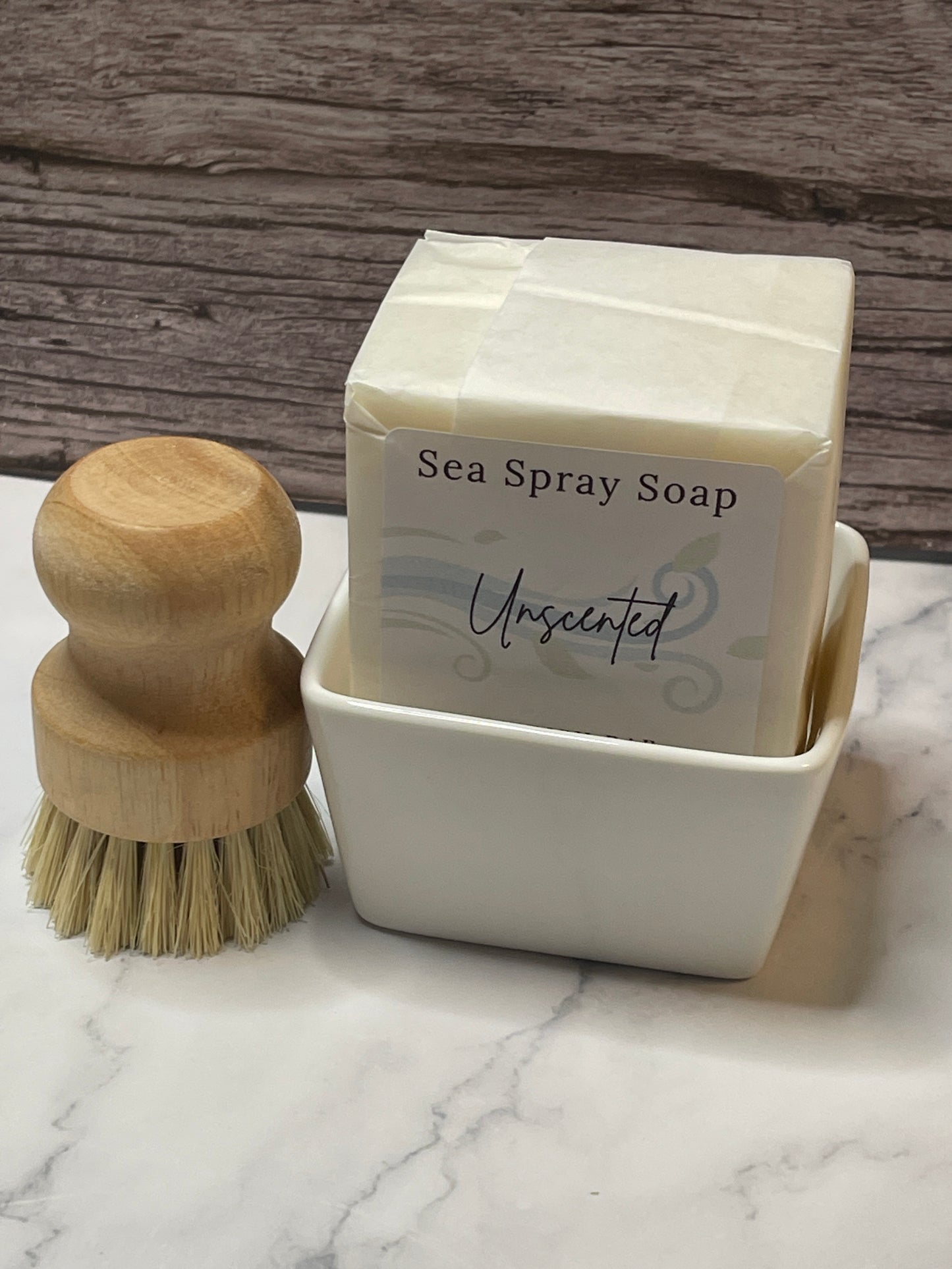 Sea spray soap bar with a wooden brush on a marble surface