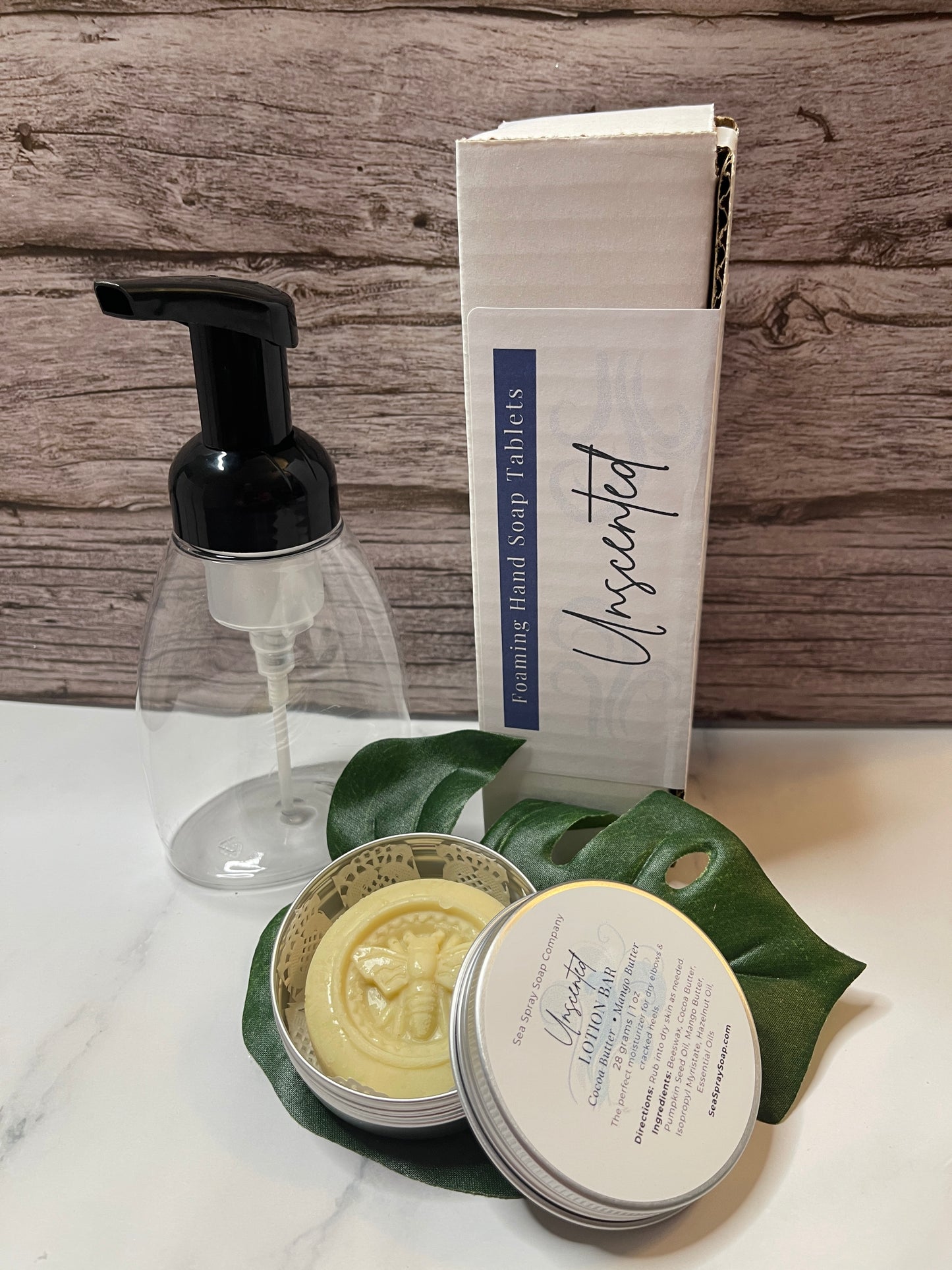 Hand soap dispenser with a bar of soap and a container of soap on a wooden surface.