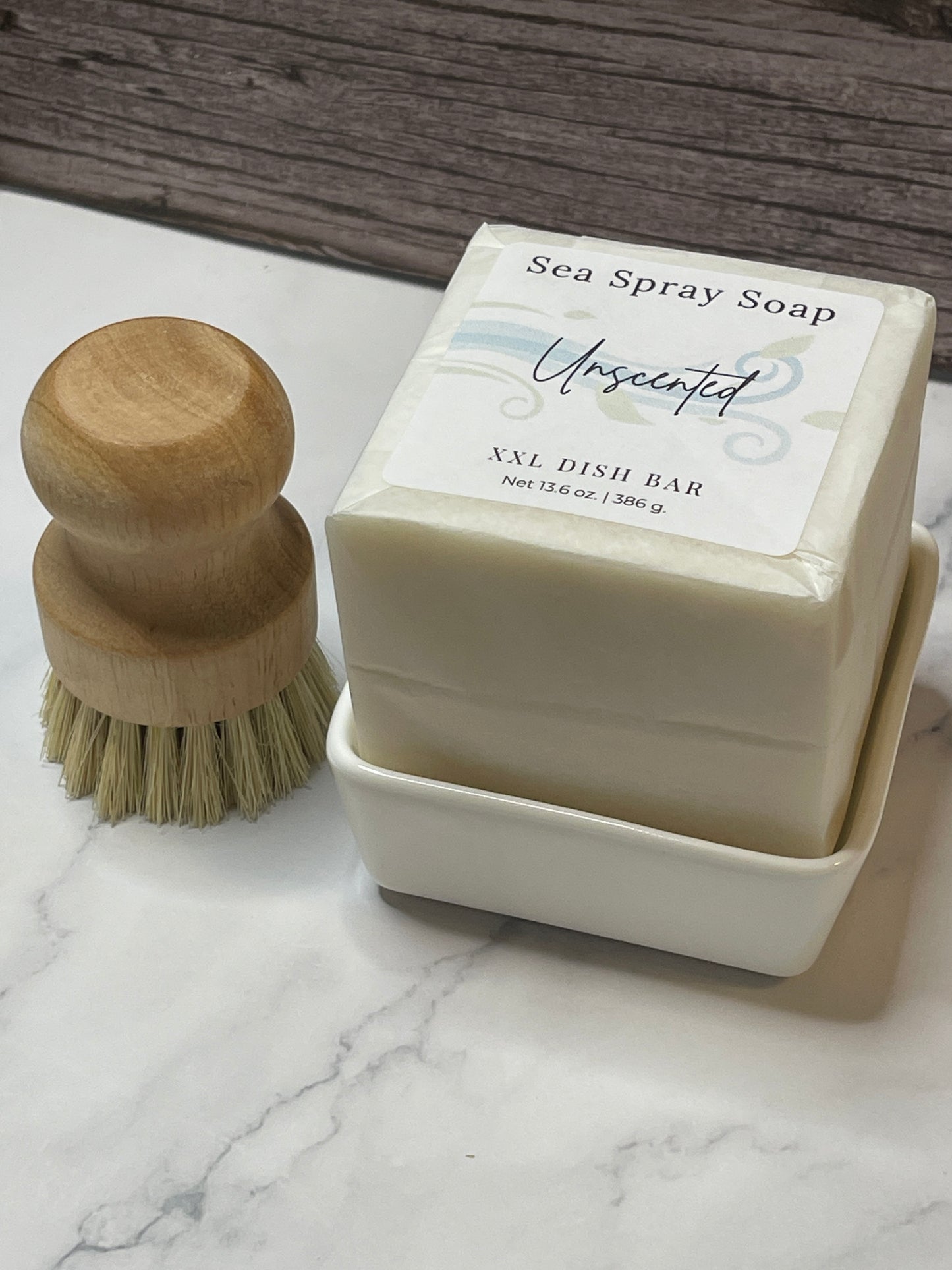 Bar of soap with a wooden brush on a marble surface
