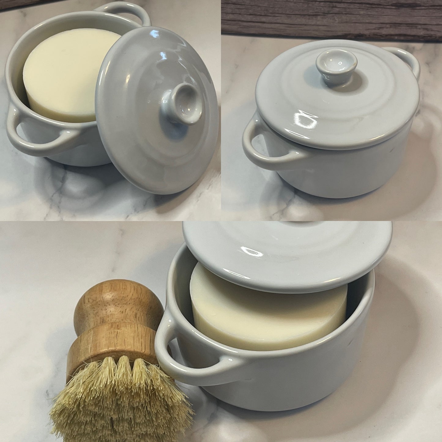 White ceramic container with lid, soap, and wooden brush on a marble surface