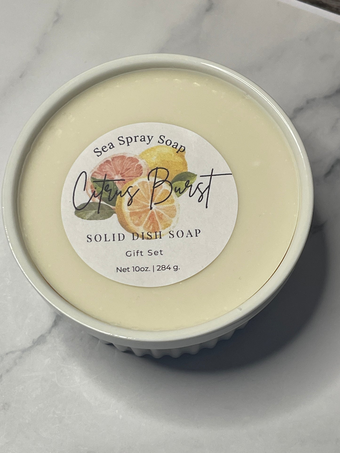 Solid dish soap with a decorative label on a marble surface