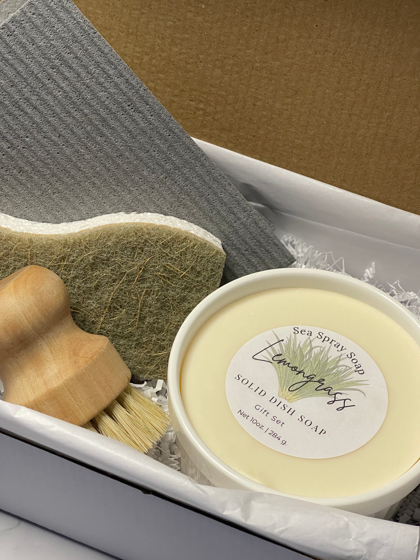 Solid dish soap with a brush and sponge on a textured surface