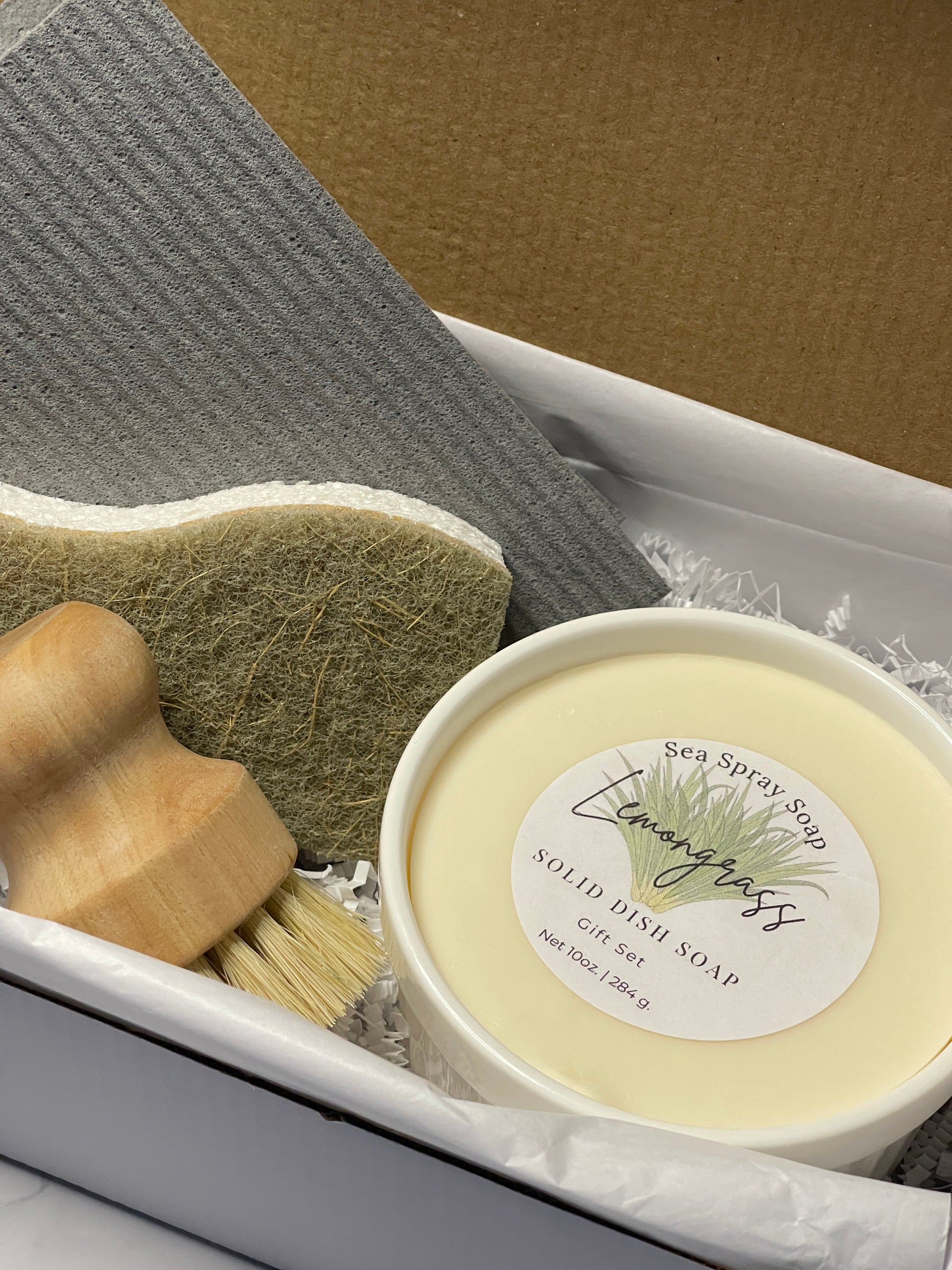 Solid dish soap with a brush and sponge on a textured surface