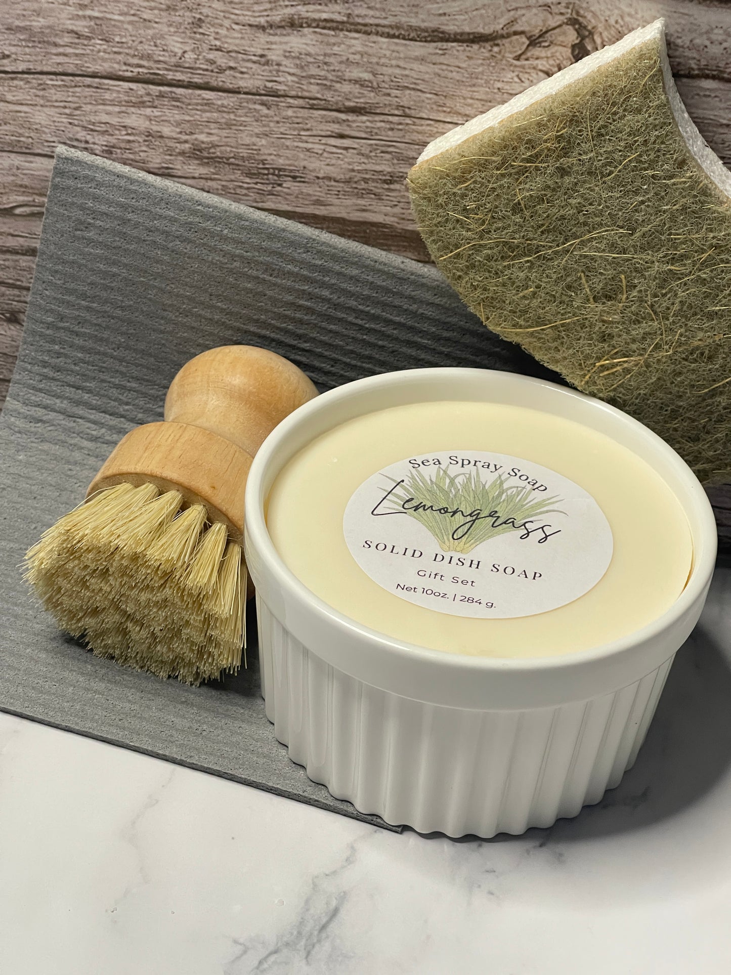 Bar of soap with a brush and loofah on a wooden surface